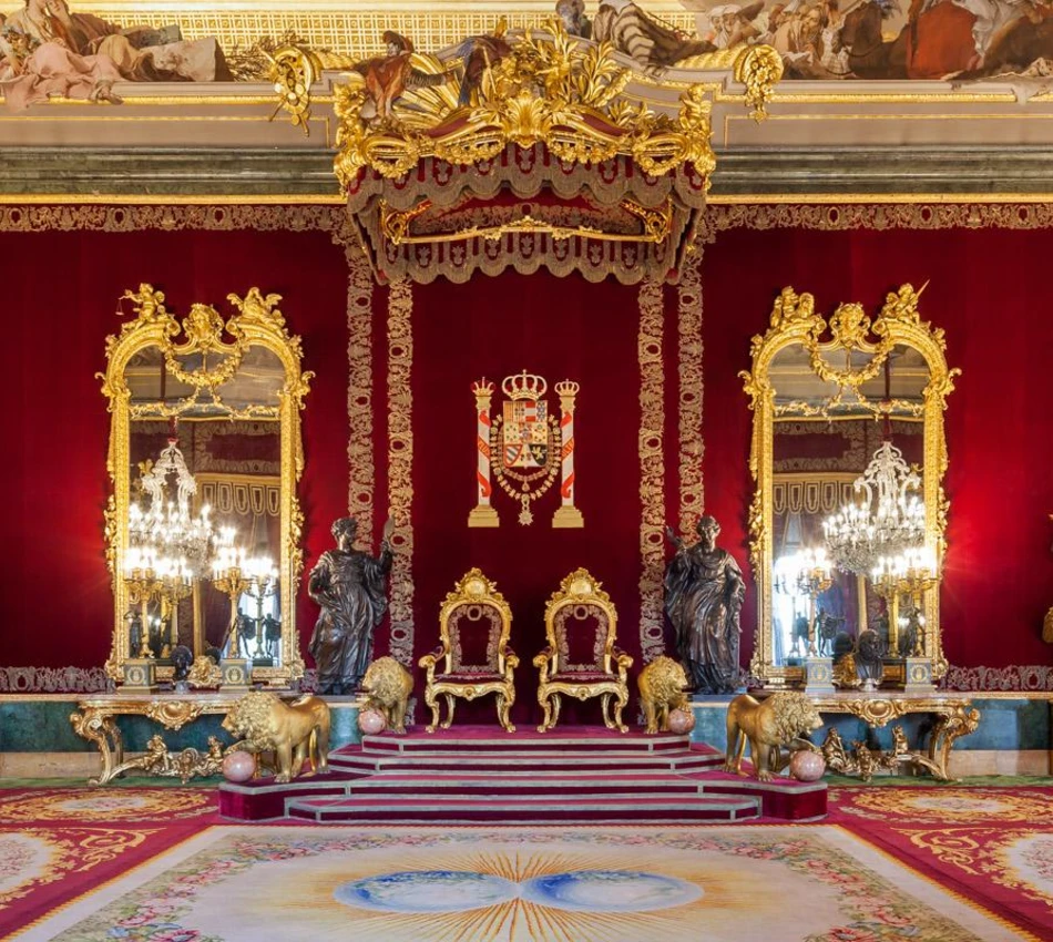 Sala de trono lujosa con tronos dorados y espejos ornamentados.