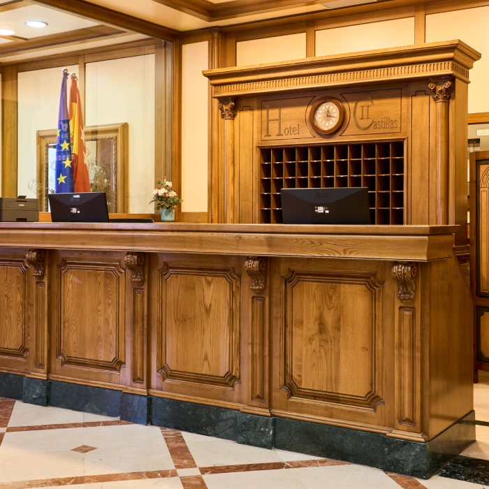 Mostrador de recepci&oacute;n de hotel con dise&ntilde;o cl&aacute;sico de madera.