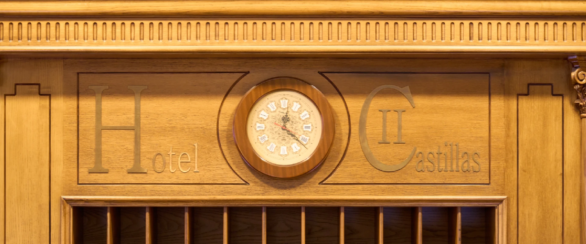 Reloj en mueble de madera con las palabras "Hotel II Castillas".