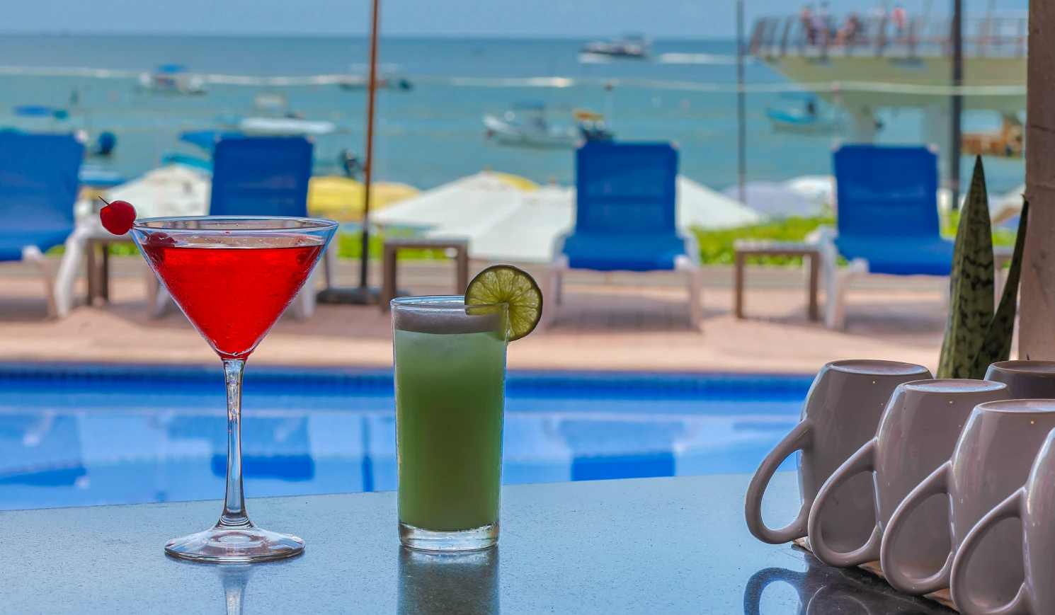 Cocktails junto a una piscina con vista al mar.