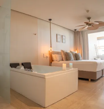 Habitaci&oacute;n moderna con ba&ntilde;era y cama, luces c&aacute;lidas y ventilador de techo.