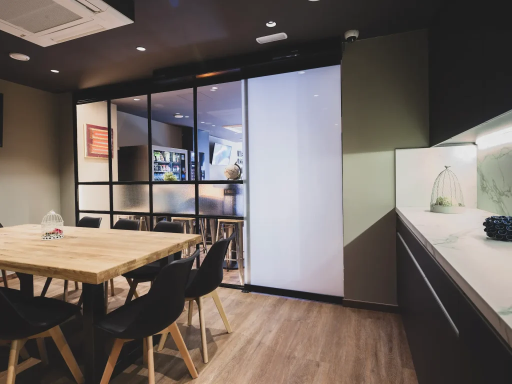 Sala de reuni&oacute;n moderna con mesa de madera y sillas negras.