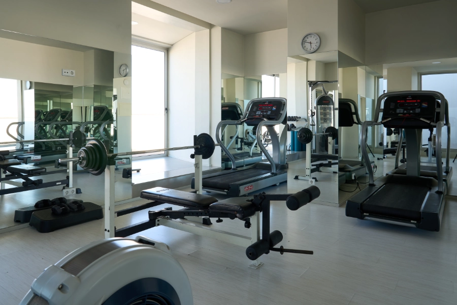 Academia moderna com esteiras e equipamentos de musculação.