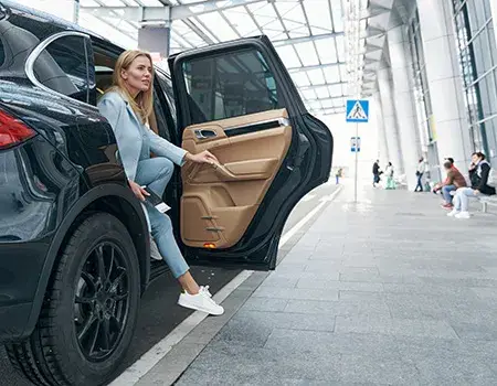 Mujer saliendo de un coche en un estacionamiento techado.
