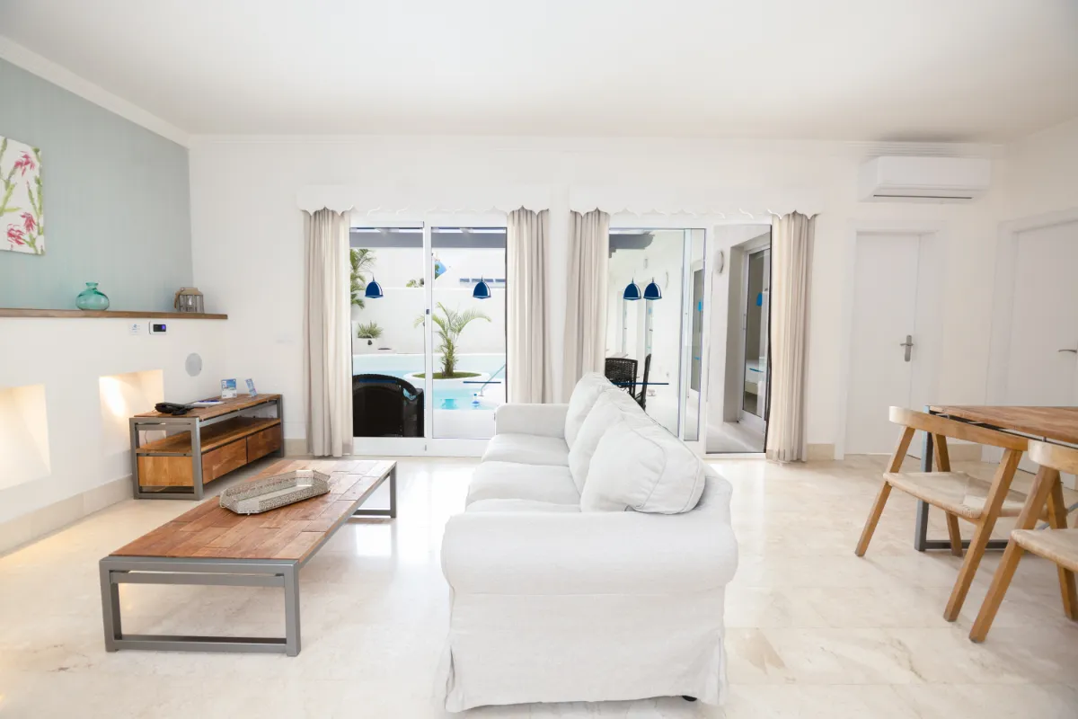 Sala de estar moderna con sofá blanco y mesa de centro de madera.
