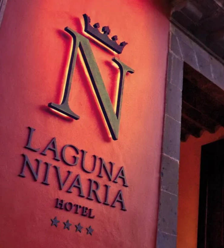 Se&ntilde;al de "Laguna Nivaria Hotel" en una pared roja con una "N" y corona.