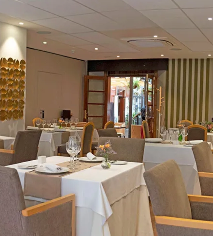 Restaurante elegante con mesas listas y decoraci&oacute;n moderna.