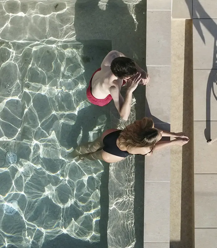 Dos personas en una piscina desde una vista a&eacute;rea.