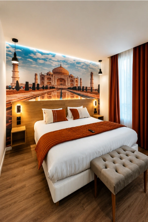 Chambre d&rsquo;h&ocirc;tel moderne avec lit, tabouret beige et fresque du Taj Mahal