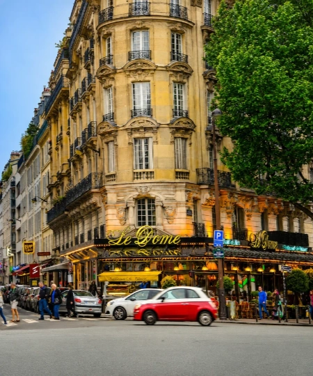 Fa&ccedil;ade haussmannienne et boutique &laquo; Le D&ocirc;me &raquo; &agrave; Paris, voitures et passants.