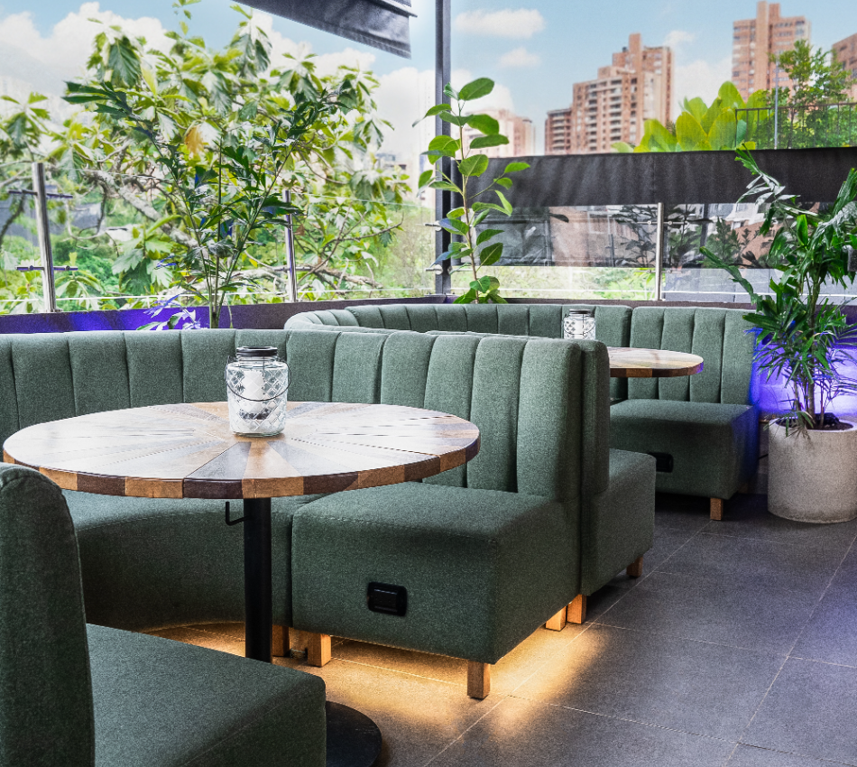 Muebles de exterior con plantas y velas, ciudad al fondo.