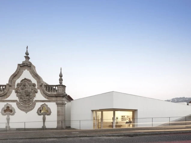 Edif&iacute;cio moderno ao lado de fachada hist&oacute;rica em uma cidade.