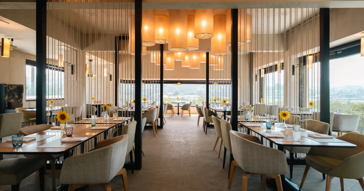 Restaurante elegante com cadeiras e mesa, girass&oacute;is na decora&ccedil;&atilde;o.