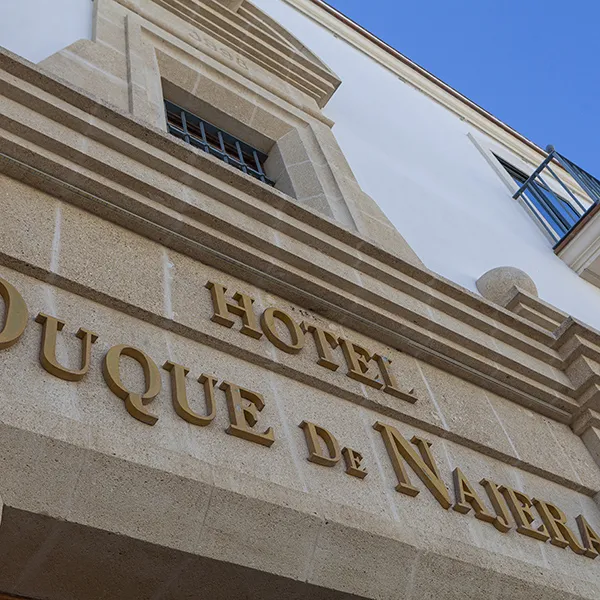 Fachada de &ldquo;Hotel Unique&rdquo; con ventanas y cielo azul.