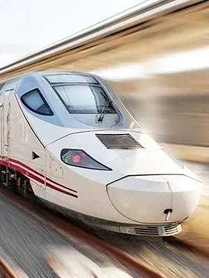 Tren bala blanco en marcha con vag&oacute;n de pasajeros desenfocado al fondo.