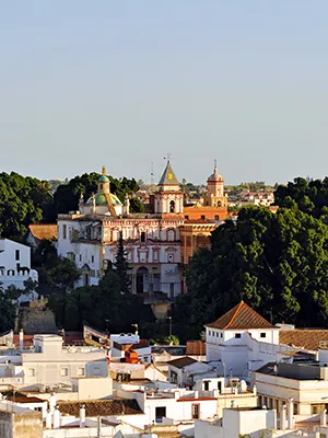 Vista panor&aacute;mica de un pueblo andaluz con iglesia y palacio entre &aacute;rboles