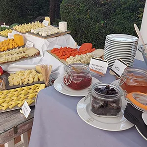 Mesa con dulces y botellas arom&aacute;ticas, al aire libre.