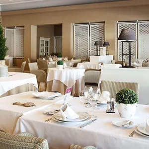 Mesa de comedor con manteles blancos y decoraci&oacute;n en un evento elegante