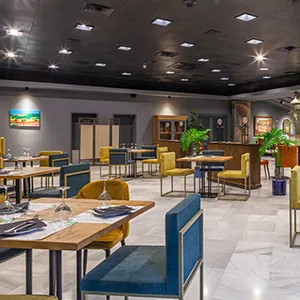 Interior de centro de eventos con mesas y sillas coloridas en sala amplia