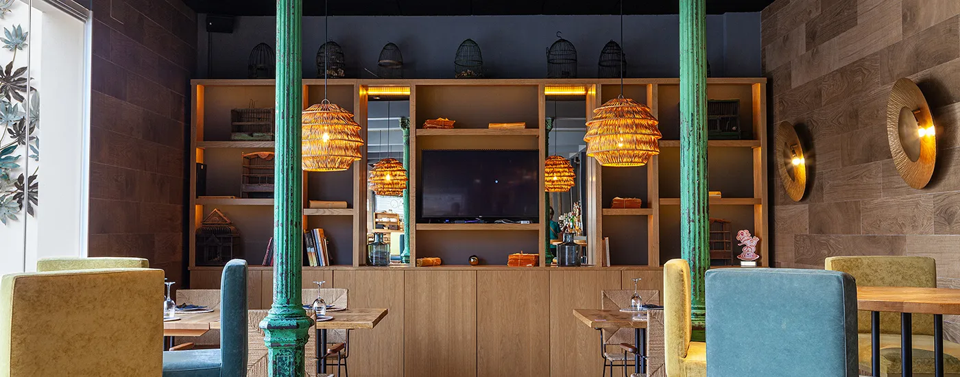 Bar con muebles de madera, luces c&aacute;lidas y l&aacute;mparas colgantes de rat&aacute;n