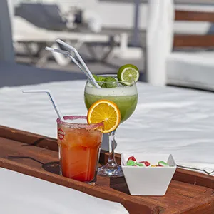 Bebidas refrescantes con rodajas de lim&oacute;n y naranja en una bandeja.