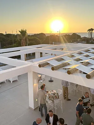 Terraza con personas en un atardecer frente a un sol brillante