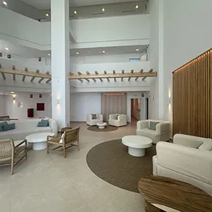 Sala de estar moderna con sillones blancos y luces empotradas.