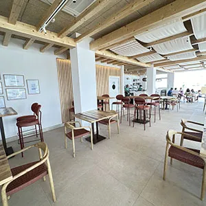 Interior de aula luminosa con mesas y sillas de madera en fila