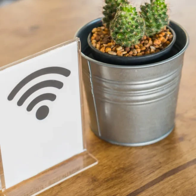 Se&ntilde;al de Wi-Fi junto a planta en maceta de metal.