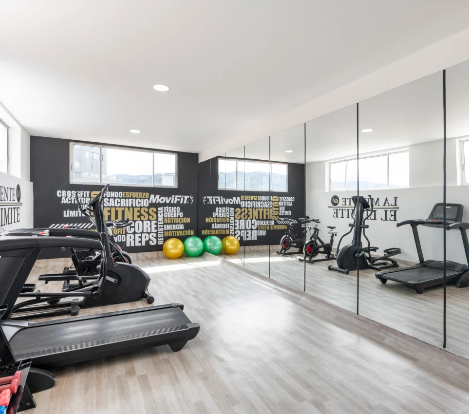 Gimnasio moderno con equipo y paredes motivacionales.