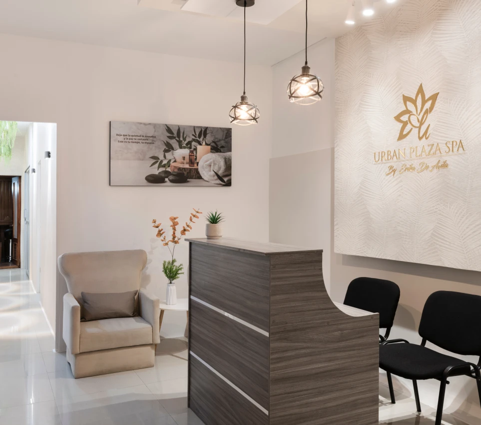 Recepci&oacute;n elegante de spa con decoraci&oacute;n minimalista y sillas negras.