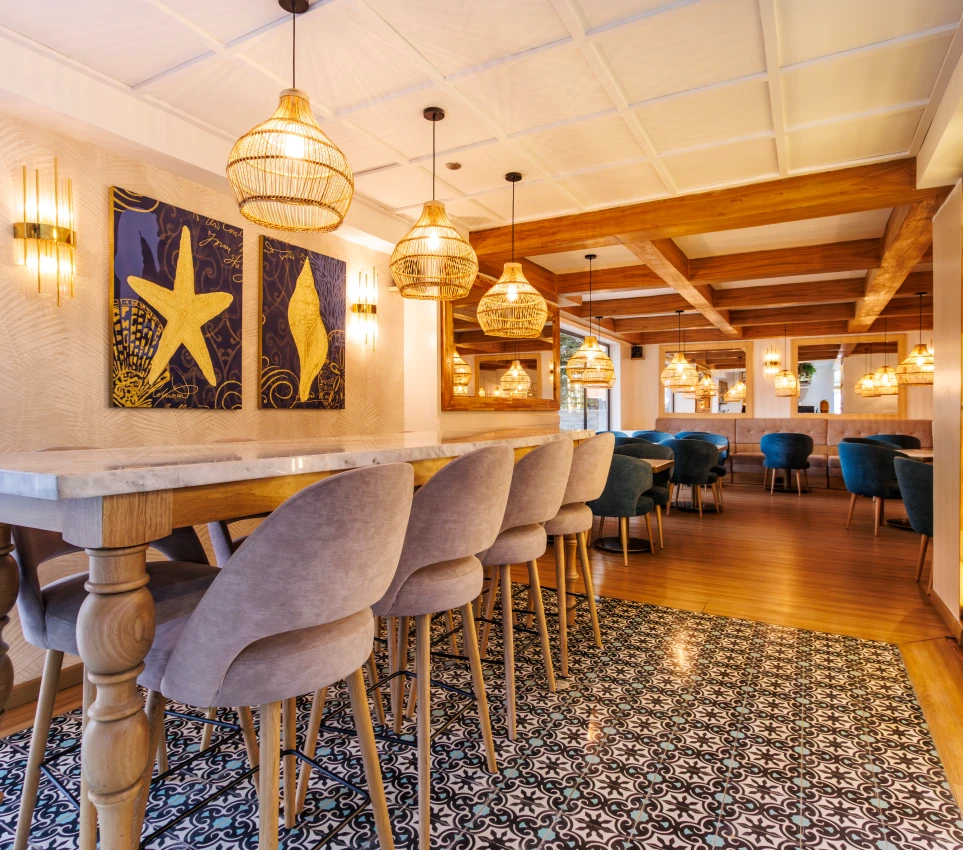 Restaurante acogedor con l&aacute;mparas tejidas y sillas elegantes.