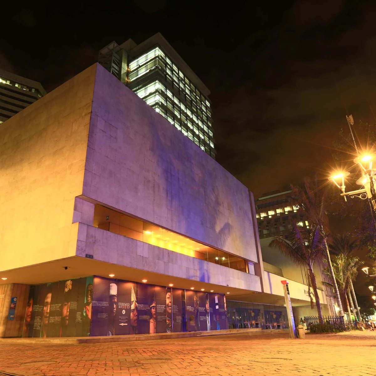 Edificio iluminado de noche con l&aacute;mparas y cielo oscuro.