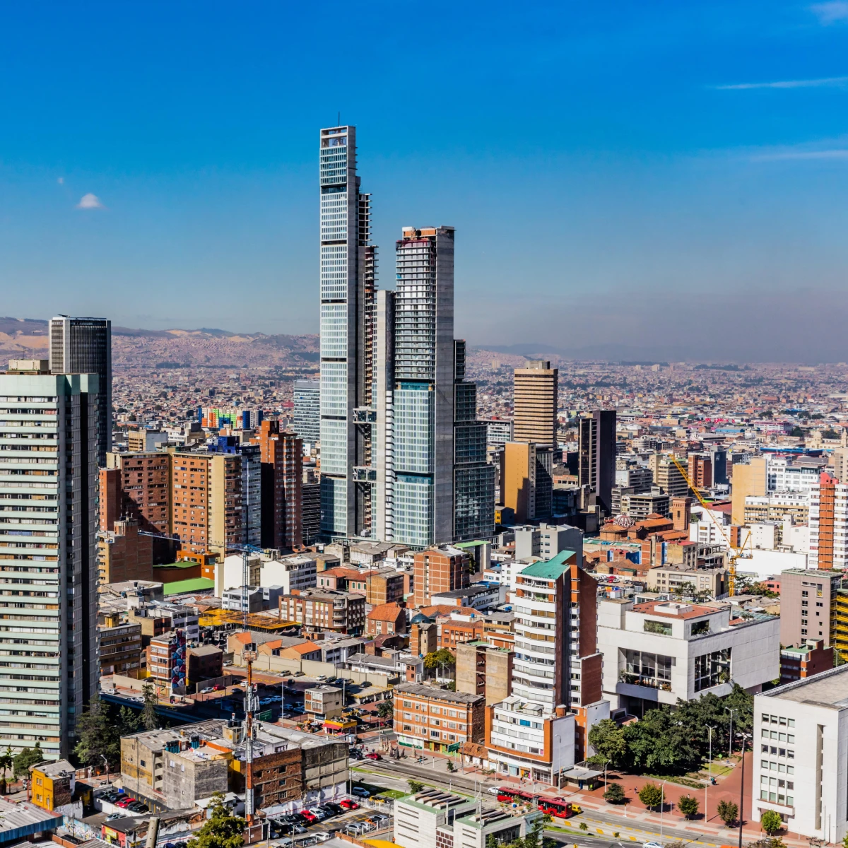 Panorama urbano con rascacielos bajo un cielo azul claro.