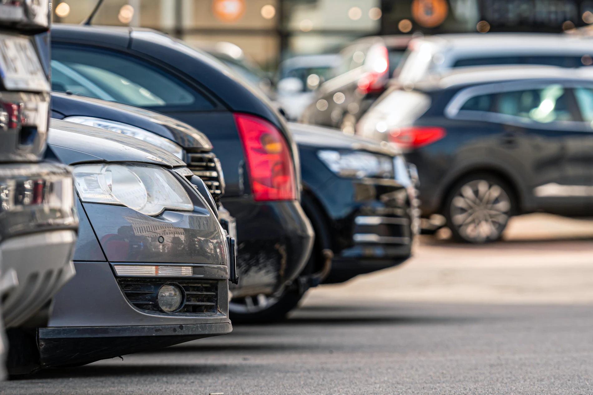 Carros estacionados em fila em um estacionamento &agrave; luz do dia.