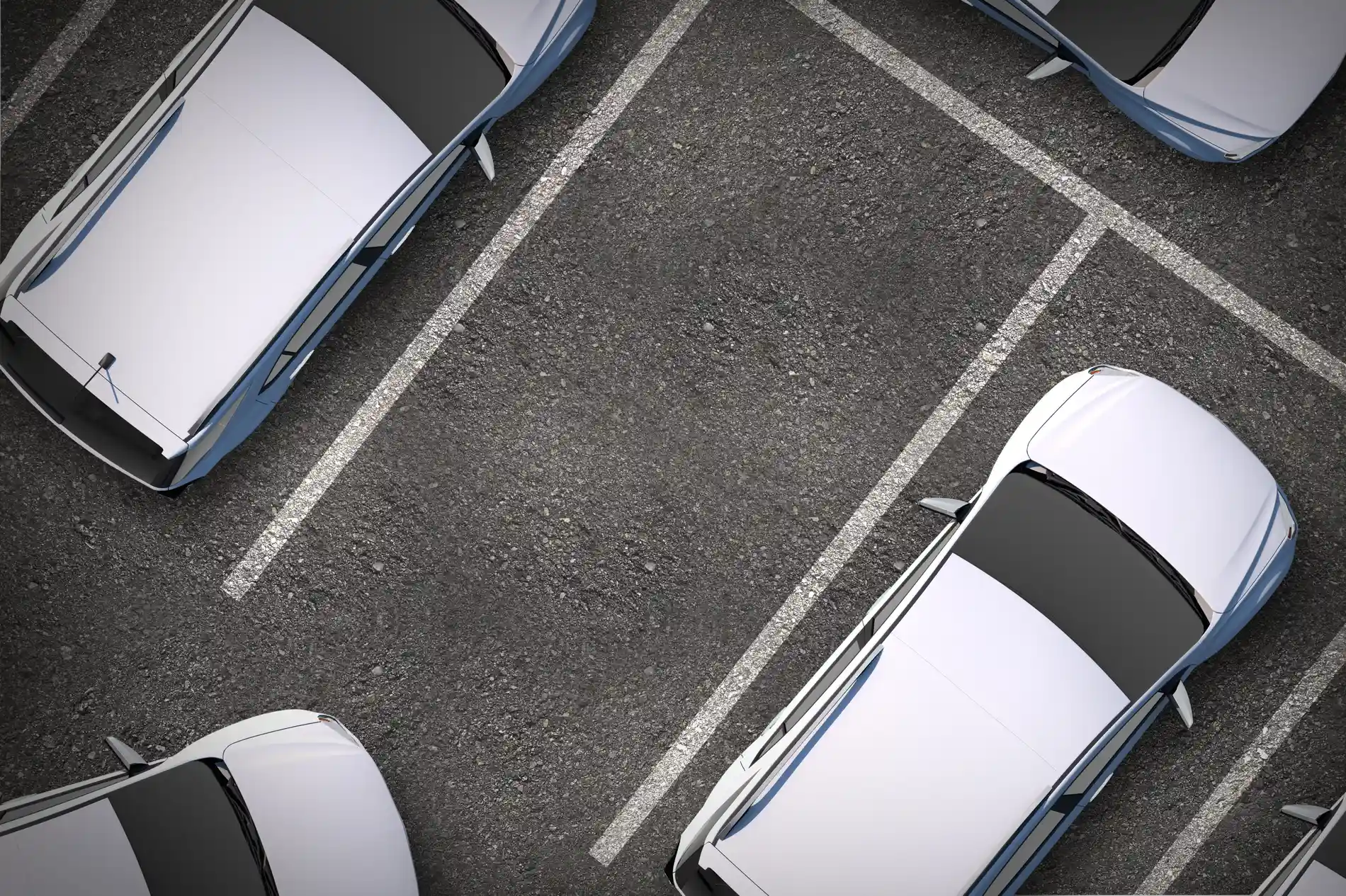 Carros estacionados em vagas demarcadas, vistos de cima.