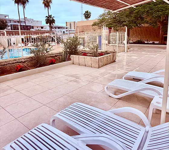 Poolside area with lounge chairs and privacy fence.