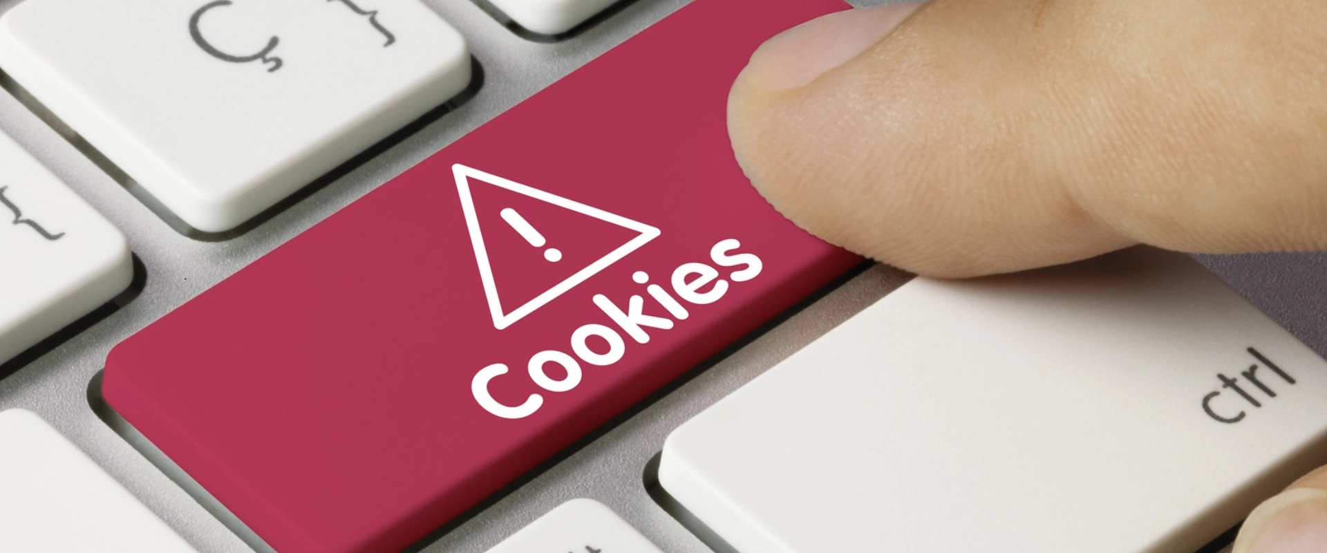 Tecla de "cookies" rosada con advertencia, presionada en un teclado.