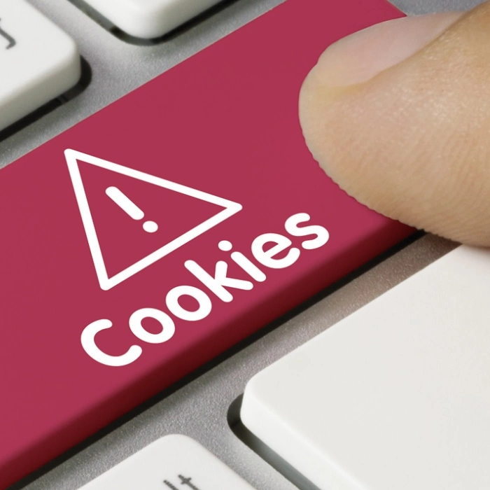 Tecla roja con advertencia de cookies y un dedo a punto de presionarla.