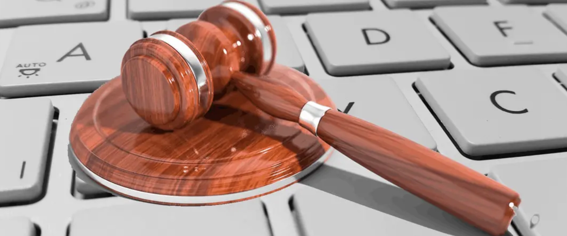 Martillo de juez sobre un teclado, simbolizando justicia digital.