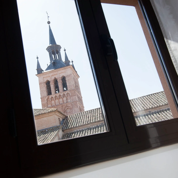 Torre de ladrillo vista a trav&eacute;s de una ventana.