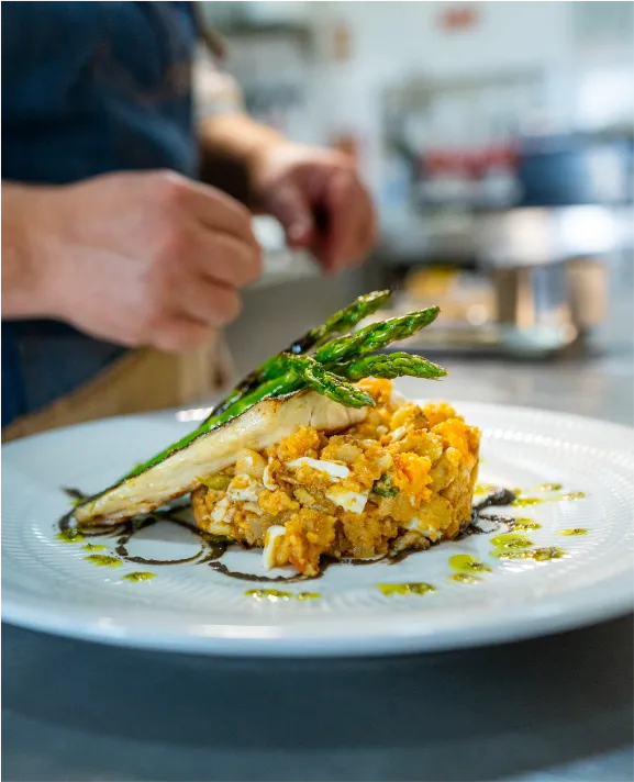 Prato gourmet com peixe, aspargos e pur&ecirc; decorado.