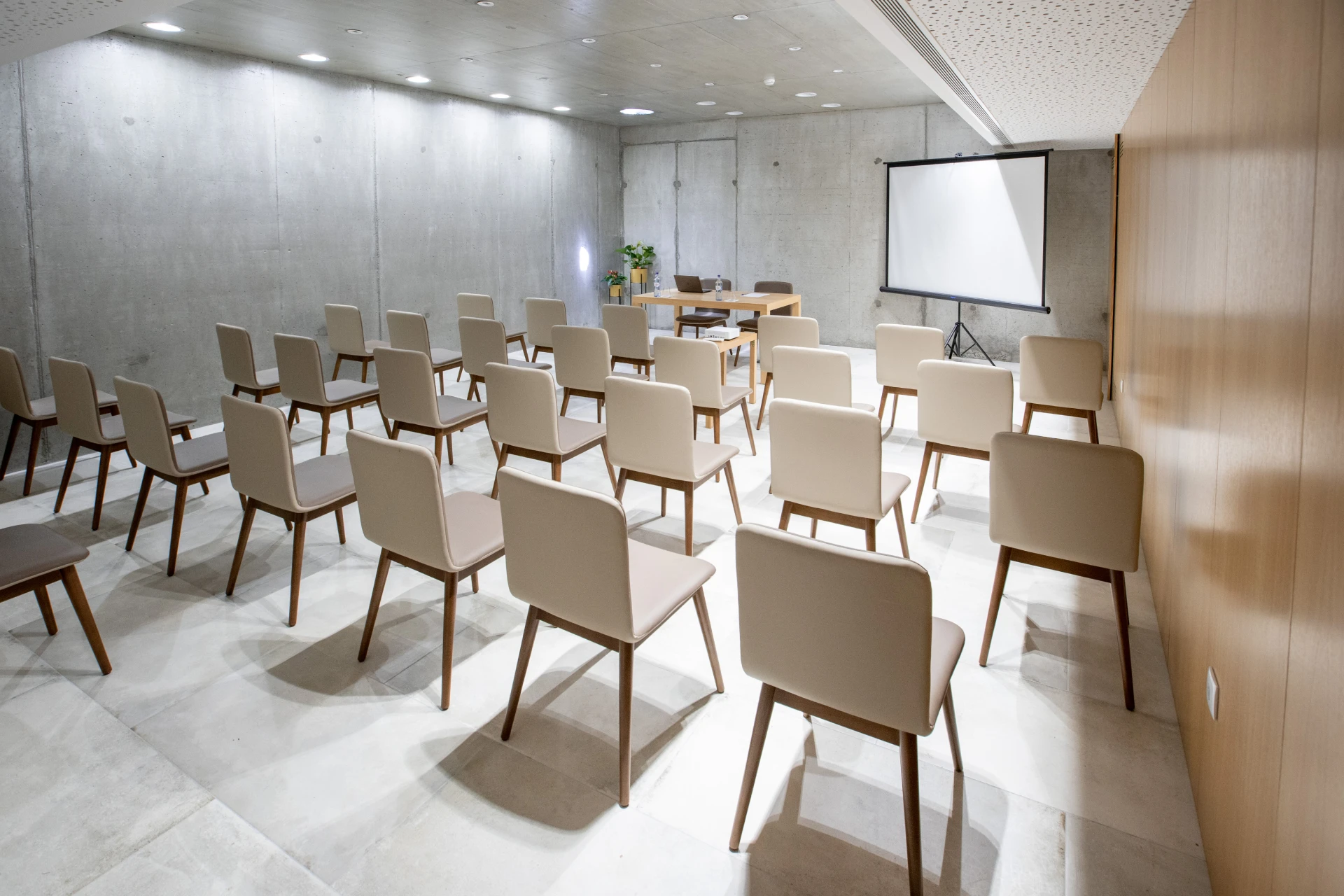 Sala de confer&ecirc;ncia vazia com cadeiras e projetor.