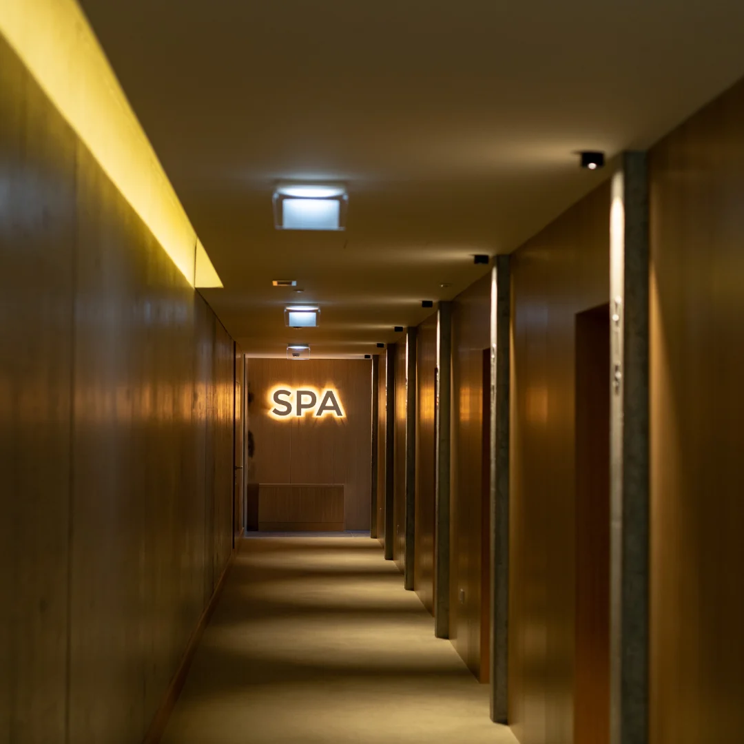 Corredor iluminado com sinal de "SPA" ao fundo.