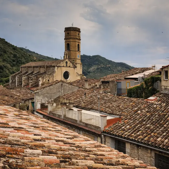Vista de teulades i l&rsquo;esgl&eacute;sia en un poble muntany&oacute;s.