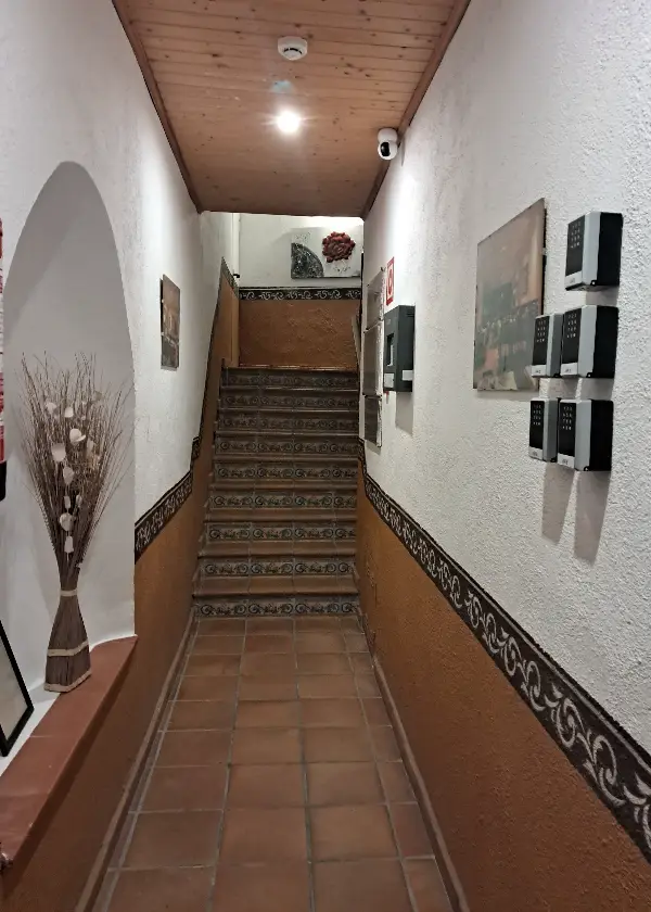 Passad&iacute;s amb esglaons decorat amb quadres i un gerro al costat esquerre.