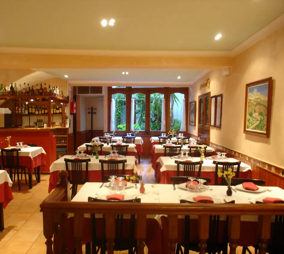 Menjador de restaurant amb taules parades i decoraci&oacute; acollidora.