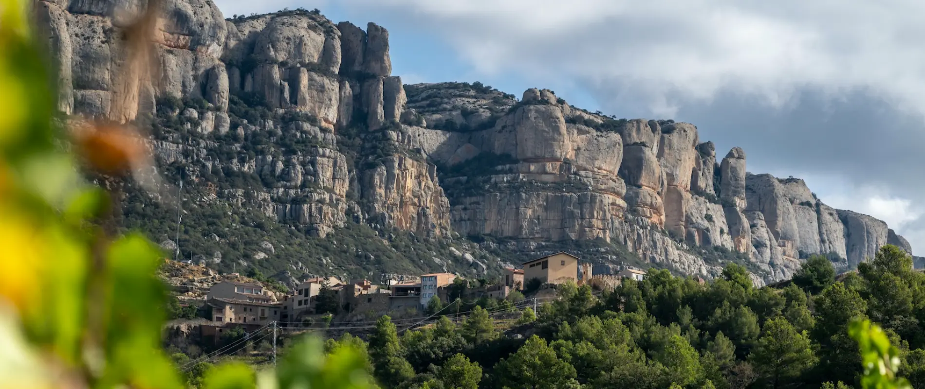 Poble pintoresc davant d'unes imponents formacions rocoses.
