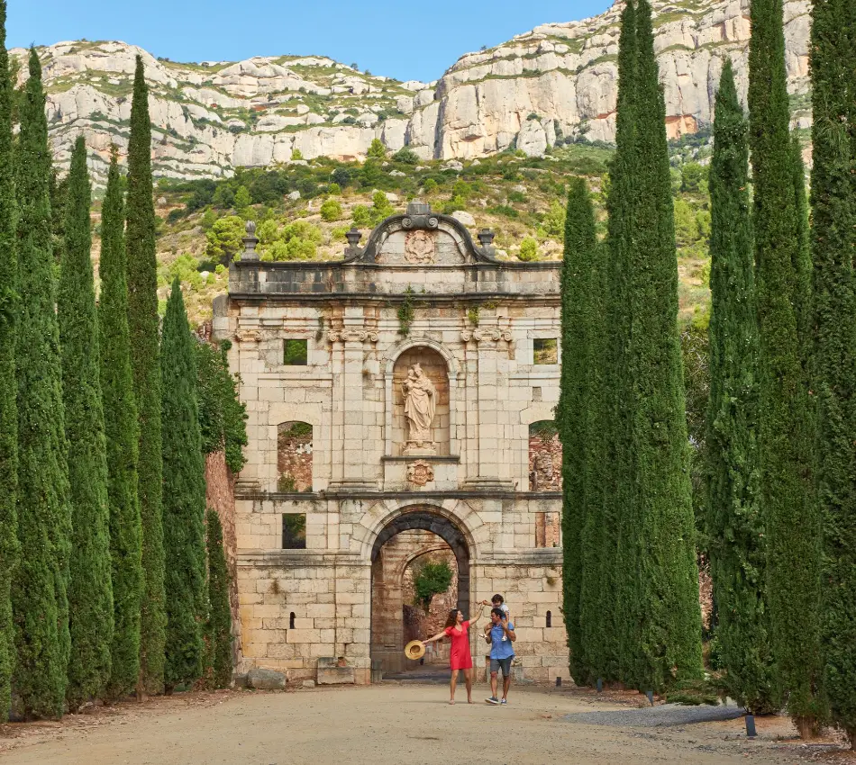 Antic portal amb xiprers al costat d'un tur&oacute; roc&oacute;s. ​
