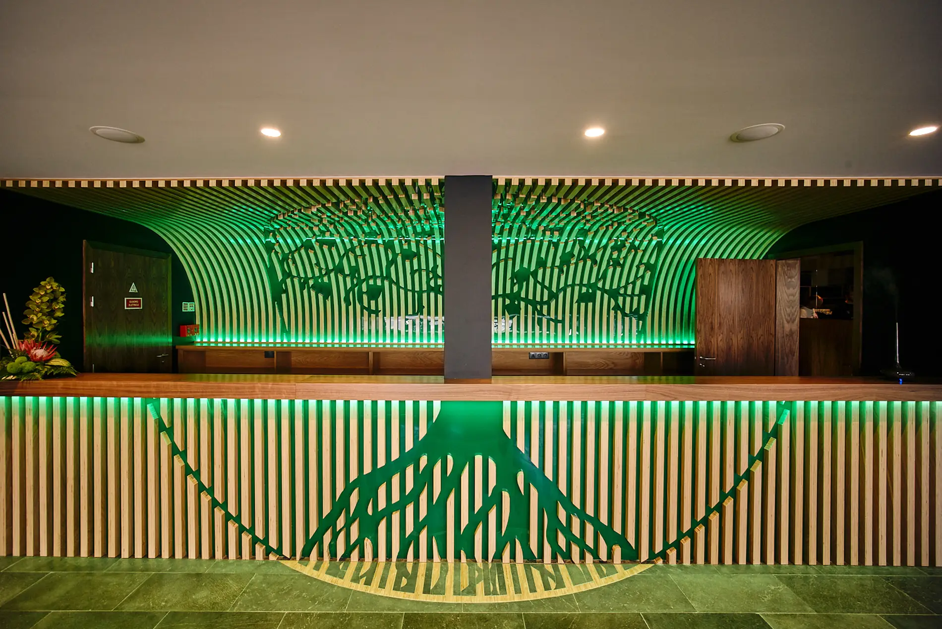 Balc&atilde;o com design de listras e luzes verdes embaixo de teto decorativo.